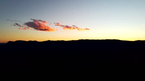 Mountain-range-silhouetted-on-skyline-by-sunset