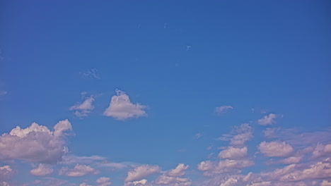 Static-time-lapse-view-of-a-blue-sky-with-white-fluffy-clouds-floating-fast-in-a-sunny-sunset