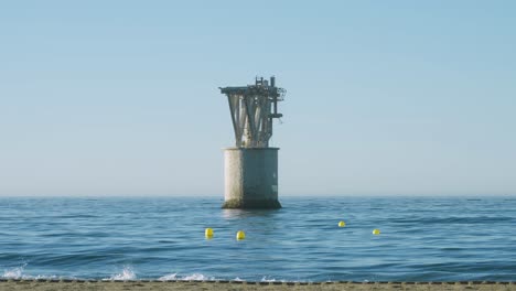 Marbella-beach-with-mine-tower-in-the-sea,-centered