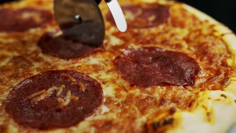 Nahaufnahme-Eines-Pizzaradschneiders,-Der-Eine-Peperoni-Pizza-Mit-Einem-Rollmesser-Schneidet,-Fast-Food-Konzept