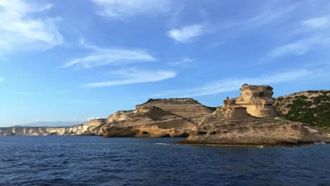 Corsica-island-cliffs-and-Capo-Pertusato-lighthouse-in-France-seen-from-touristic-boat,-50fps