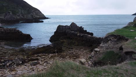 Urban-exploration-on-edge-of-eroded-Welsh-coastline-overlooking-harsh-rock-beach-and-Irish-sea