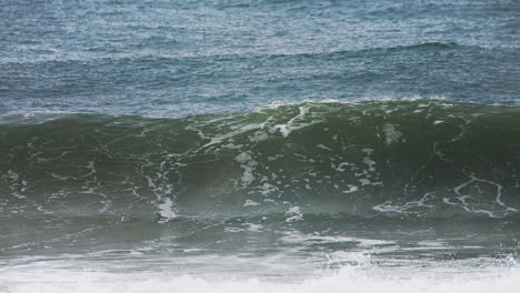 Große-Welle,-Die-Sich-In-Zeitlupe-Am-Ufer-Bildet-Und-Zusammenbricht,-Mit-Einem-Tief-Dunkelblauen-Ozean-Dahinter-Und-Weißem-Wasser,-Das-In-Hochgeschwindigkeitskamera-120-Fps-4k-Aufnahmen-Verschüttet-Wird