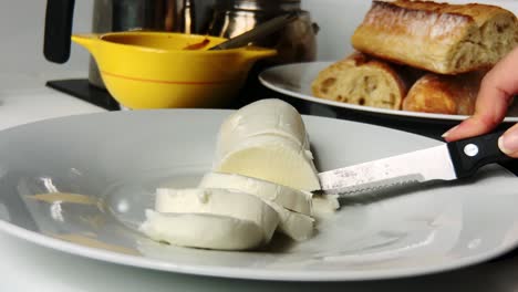 Person-Cutting-Fresh-Mozzarella-Cheese-With-A-Knife