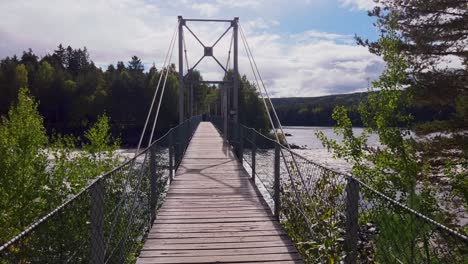 Pan-Schöne-Aussicht-Auf-Einen-Ruhigen-Fluss,-Umgeben-Von-üppigem-Grün-Mit-Einer-Brücke-Darüber