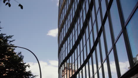 Glasfront-Des-Bürogebäudes-Gegen-Den-Blauen-Himmel-Mit-Vorbeiziehenden-Wolken-1