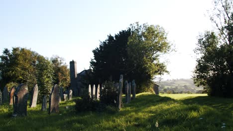 Welsh-grave-yard-at-sunset,-church-in-background