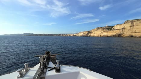 Segelboot-Bugperspektive-Des-Navigationsboots-In-Richtung-Der-Klippen-Der-Insel-Korsika-Und-Des-Leuchtturms-Capo-Pertusato-In-Frankreich,-50-Fps