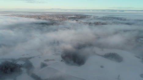 Aerial-View-of-White-Winter-Landscape-and-Fog-Above-Mountain-Hills,-Drone-Shot