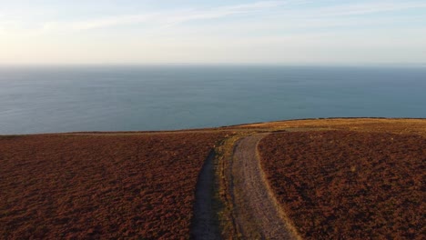 Coastal-Sunset-with-Wide-Hiker-Path-with-Ocean-Background-in-North-Devon-UK-4K---Aerial-Drone-Footage