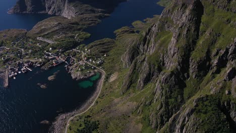 Norwegian-fishing-village-nestled-between-mountains,-lake-and-ocean-in-the-Lofoten-Islands