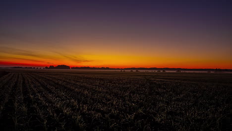 Time-Lapse,-Sunset-and-Dusk-Above-Plain-Farming-Field,-Clear-Sky-Changing-Colors-From-Yellow-to-Purple