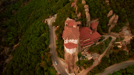 Drone-tilt-down-view-of-Greek-monastery-perched-atop-rock-column