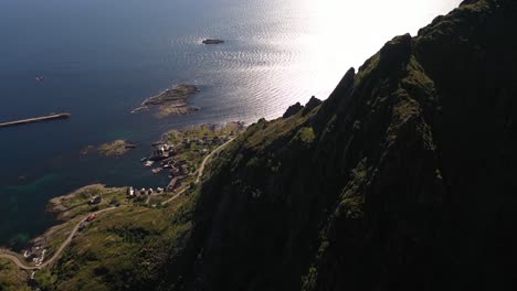 Rough-landscape-of-the-Lofoten-with-mountains-dropping-into-the-sea-and-a-village-by-the-coast