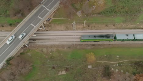 Top-Down-Aerial-View-Of-The-Historical-Philip-II-Train-Heading-Along-The-Train-Tracks-And-under-A-Bridge