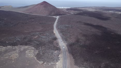 Aerial-shot-of-road-and-moving-cloud's-shadow-in-the-volcanic-area