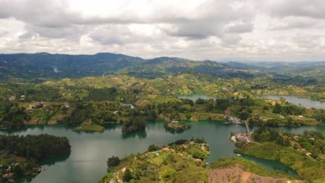 Guatape-Landscape-Aerial-Drone-Fly-Above-Green-Land-Blue-Lake-Colombian-Tourism-Famous-Destination