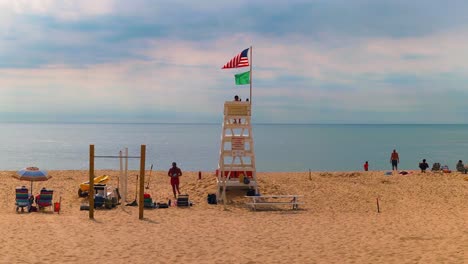 Flags-Waving-With-The-Wind-At-Lifeguard-Tower-In-East-Hampton-Beach,-Suffolk,-New-York