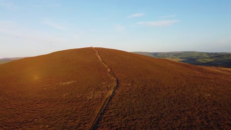 Beautiful-Sunset-Rising-Aerial-Drone-Footage-Over-Moorland-with-Hiker-Tourist-Path-on-Holdstone-Down-North-Devon-UK-4K