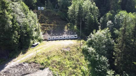Targets-at-outdoor-shooting-range-close-to-strandaelvi-river-in-Voss-Norway---Sunny-day-aerial-moving-backwards-from-targets