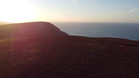 Luftaufnahmen-Des-Sonnenuntergangs-Mit-Blick-Auf-Das-Küstenmeer-Auf-Moor-Mit-Vögeln,-Die-In-Der-Nähe-In-North-Devon-Uk-4k-Fliegen