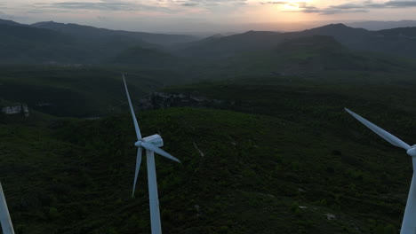 Drone-view-of-wind-turbines-at-dusk-at-Trucafort,-Pradell-de-La-Teixeta-in-province-of-Tarragona-in-Spain