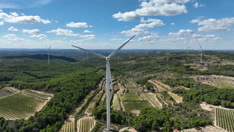 Blue-sky-over-spinning-wind-turbine-in-wind-mill-park-of-Coll-de-Moro-in-Catalonia,-Spain
