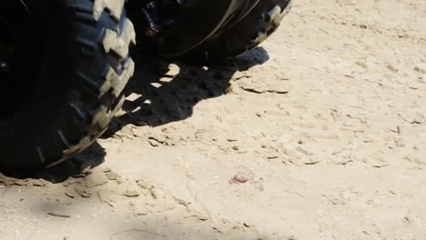 Slow-motion-ATV-wheels-spinning-on-the-beach-sand