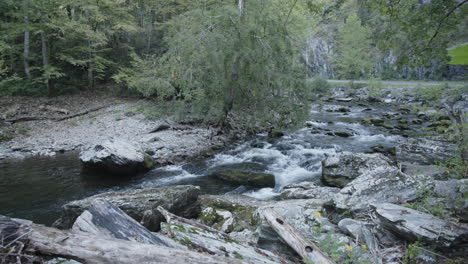 Wide-slow-motion-footage-of-a-creek-with-water-flowing-over-rocks