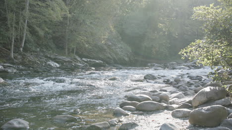 Slow-motion-footage-of-a-creek-in-the-Smoky-Mountains-National-Park-with-morning-sunlight-streaming-down-in-the-haze