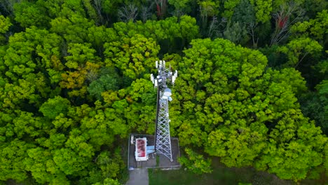 Orbital-aerial-of-a-communications-tower-in-the-middle-of-forest-trees
