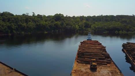 Deforestation:-loading-and-stacking-logs-from-the-Amazon-rainforest-onto-barges-for-transport---Aerial-flyover