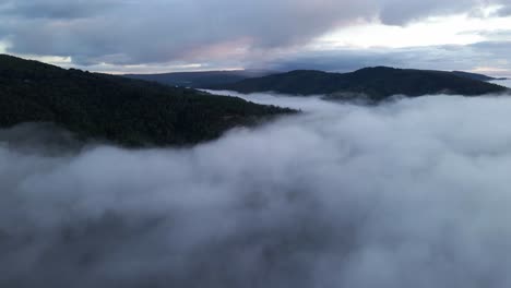 Landscape-aerial-view-above-the-clouds-of-the-forest-in-the-mountains-and-horizon-in-Chile