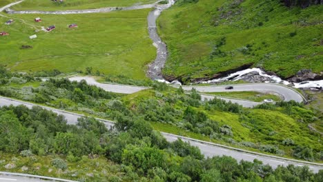 Aerial-from-Vikafjell-winding-mountain-roads-with-slow-tilt-up-to-reveal-stunning-lush-green-valley-Kvassdal-and-Holedal---Norway