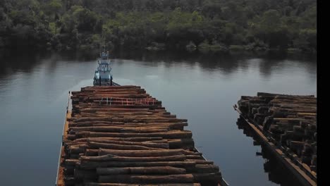 Deforestation-of-the-Amazon-rainforest:-logs-stacked-on-barges-for-shipping-down-the-Tocantins-River---aerial-flyover