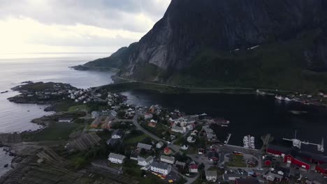 Reine-fishing-village-below-overshadowing-mountain,-Moskenesoya-island-in-Norway