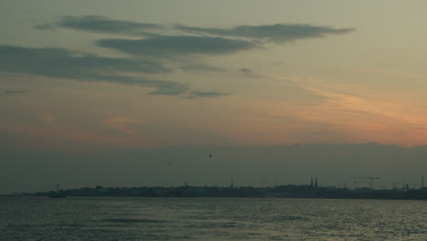Stadtsilhouette-Bei-Sonnenuntergang-Mit-Möwen-Und-Ruhigem-Meer-In-Helsinki,-Finnland-An-Einem-Warmen-Sommertag