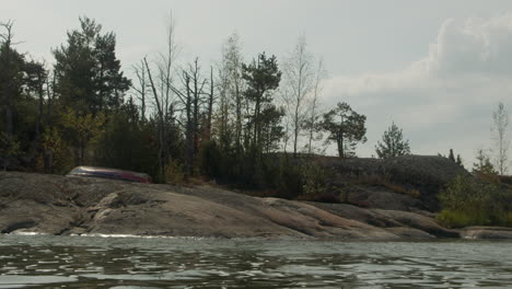 Altes-Ruderboot-An-Einem-Felsigen-Inselstrand-Im-Finnischen-Archipel-Mit-Sanften-Wellen-Und-Entspannter-Atmosphäre-4k