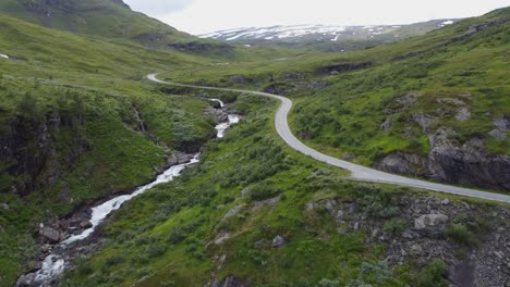 Drone-climbing-up-last-hill-and-revealing-Vikafjellet-RV-13-road-mountain-crossing-in-western-Norway---Summer-evening-aerial