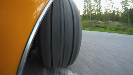4k-Close-up-of-a-retro-car-wheel-while-driving-on-a-road