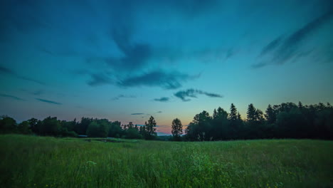 Low-Angle-View-Grasland-Mit-Baumsilhouette-Bei-Sonnenaufgang,-Wolken,-Die-Den-Blauen-Himmel-überqueren,-Zeitraffer