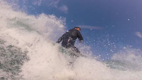 Close-up-slow-motion-shot-of-Handsome-guy-surfing-a-green-wave-in-guincho-surf-spot-1