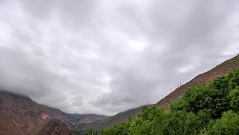 The-wind-blows-clouds-between-two-mountain-peaks-in-summer---overcast-cloudscape-time-lapse