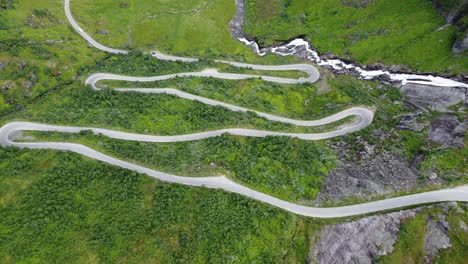 Halsabakkane-winding-roads-leading-to-Vikafjellet-mountain-crossing-in-western-Norway---Unique-curvy-road-climbing-up-steep-mountain-hill-in-lush-green-valley---Descending-birdseye-aerial