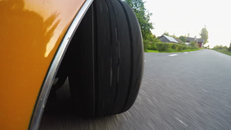 4k-Close-up-from-the-side-of-a-retro-car-wheel-while-driving-on-a-road