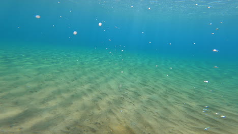 Seabed-underwater-footage,-sand-with-ripples-and-opaque-blue-water,-action-cam
