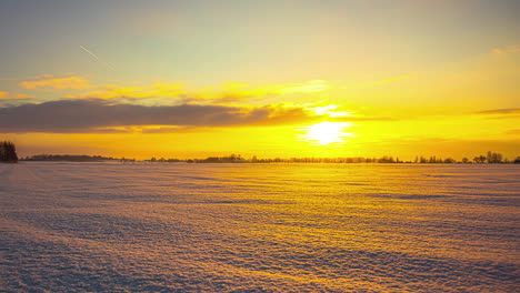 Wunderschöner,-Leuchtend-Orangefarbener-Zeitraffer-Des-Sonnenuntergangs-über-Der-Verschneiten-Landschaft