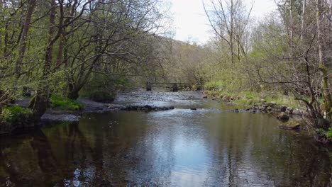 A-running-shot-over-the-river-Rothay-at-white-moss-walks,-scenic-forest-recreational-area-in-peak-district