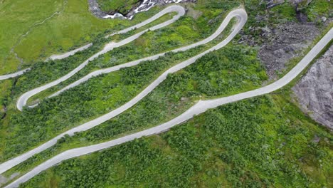 Unique-Norwegian-winding-roads-leading-to-mountain-crossing-Vikafjell-along-road-rv13---Top-down-birdseye-aerial-looking-down-at-steep-hillside-with-crazy-curves