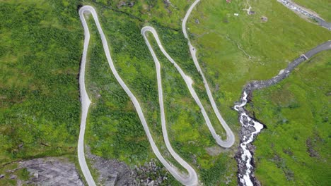 Special-winding-roads-at-Halsabakkane-close-to-Sendefossen-in-Vikafjellet-mountain-crossing-Norway---Unique-birdseye-perspective-looking-down-at-curvy-road-climbing-up-steep-mountain